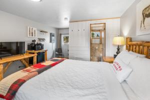um quarto com uma grande cama branca num quarto em The Bucking Moose em West Yellowstone