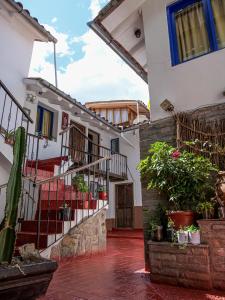 ein Gebäude mit Treppen und Topfpflanzen im Innenhof in der Unterkunft Hotel Guest House Wayra in Cusco