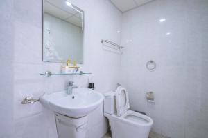 een witte badkamer met een wastafel en een toilet bij Homestay Hạ Long 3 phòng ngủ view biển in Ha Long