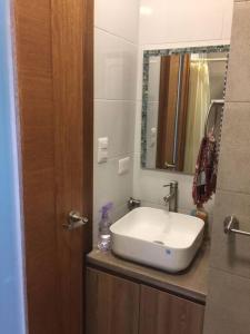 een badkamer met een witte wastafel en een spiegel bij Dep. Salinas, Chipipe. in Salinas