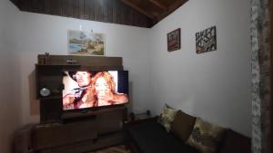 uma sala de estar com uma televisão de ecrã plano em Apartamento Refúgio MV em Monte Verde