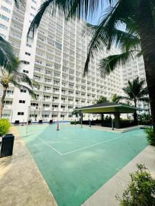 a tennis court in front of a large building at 1 bedroom unit condo in Manila