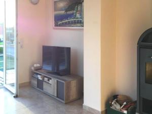 TV de pantalla plana sentada en un stand en una habitación en Holiday Home with private pool in Sant Pere Pescador, en Sant Pere Pescador