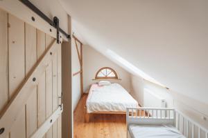 małą sypialnię na poddaszu z łóżkiem i oknem w obiekcie Duży Apartament Duszniki-Zdrój w mieście Duszniki Zdrój