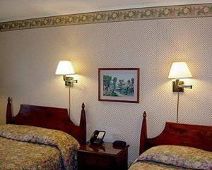a hotel room with two beds and two lamps at West Road Motel in Bennington
