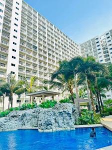 a person in a pool in front of a large building at 1 bedroom unit condo in Manila