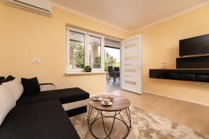 a living room with a couch and a table at Apartments Vugrin in Šilo