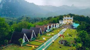 an aerial view of a building in a field with a mountain at 99 Camp and Cafe in Khao Sok