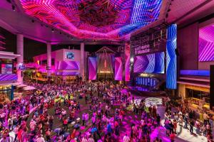 a crowd of people dancing in a room with purple lights at Domo Arigato 3 in San Juan