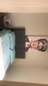 a picture of a woman on a wall next to a bed at Apto en Flandes Palma real in Flandes
