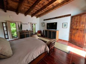 Schlafzimmer mit einem Bett und einem Flachbild-TV in der Unterkunft Casa de campo ideal para descansar y desconectarse in Valle de Bravo