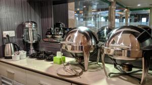 a kitchen with three large silver bowls on a counter at Kita Hotel in Tanjung Pinang 