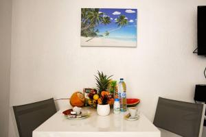 a white table with a bowl of fruit on it at Paradis studio & plage à 1 min in Le Gosier