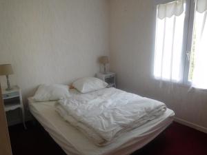 a bed with white sheets and pillows in a bedroom at Maison spacieuse 9 pers, secteur calme - FR-1-476-201 in La Faute-sur-Mer