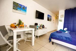 a bedroom with a desk and a bed and a desk at Paradis studio & plage à 1 min in Le Gosier