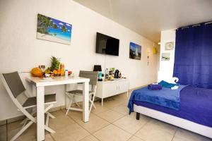 a bedroom with a bed and a desk and a bed and a table at Paradis studio & plage à 1 min in Le Gosier +55 photos