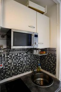a kitchen with a sink and a microwave at Paradis studio & plage à 1 min in Le Gosier