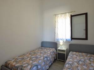 a small bedroom with two beds and a window at Holiday Home Floridia with Private Pool in Floridia