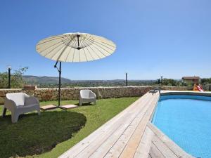 an umbrella and chairs next to a swimming pool at Holiday Home Floridia with Private Pool in Floridia