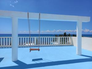 un columpio en un porche con el océano en el fondo en Hotel Posada Sian Kaan Playa del Carmen en Playa del Carmen