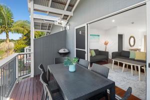 un patio con tavolo e sedie sul balcone. di The Observatory Self Contained Apartments a Coffs Harbour