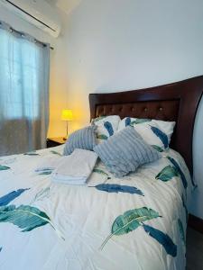 ein Bett mit blauen und weißen Kissen darauf in der Unterkunft Tavalero Rooms in Santo Domingo