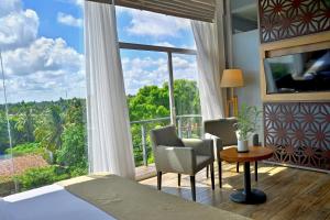 een slaapkamer met een bed en een groot raam bij Belmont Boutique Hotel in Negombo