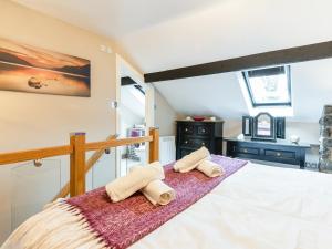 1 dormitorio con 1 cama con toallas en Ty Bach Twt, en Dyffryn