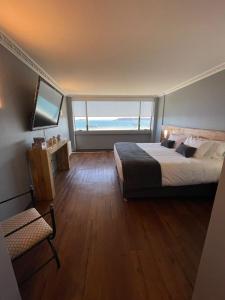 una camera con un grande letto e una grande finestra di Gran Hotel Versalles Puerto Montt a Puerto Montt