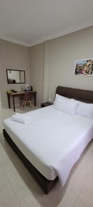 Cukai的住宿－HOTEL SHAFURA 3，一张大白色的床,位于带书桌的房间里