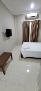 a bedroom with a bed and a tv in it at HOTEL SHAFURA 3 in Cukai