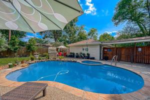 uma piscina com um guarda-sol e uma casa em Houston’s 4 BR 2B with Pool em Houston