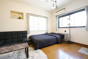 1 dormitorio con 1 cama y 1 sofá en PLAZA IKEJIRI 201, en Tokio
