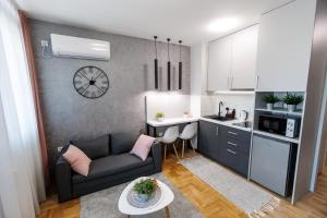 een kleine woonkamer met een bank en een keuken bij Apartman Tija 3 in Subotica