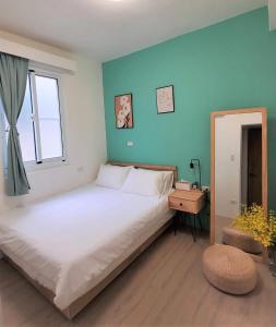 sypialnia z dużym białym łóżkiem i oknem w obiekcie Good Stay w mieście Tainan