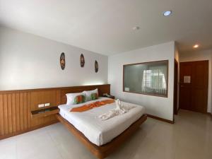 a bedroom with a large bed and a flat screen tv at One World One Home Patong 2 in Patong Beach