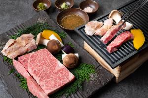 a grill with different types of meat and vegetables at Kusayane no yado Ryunohige in Yufu