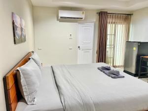 een slaapkamer met een bed en een tv. bij The Gun Hotel 8 in Surin