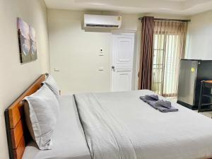 a bedroom with a bed and a tv in it at The Gun Hotel Premium in Surin