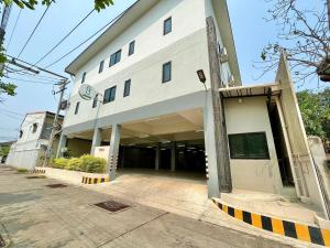 a large white building with an open door at The Gun Hotel 8 in Surin