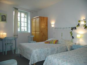 sypialnia z 2 łóżkami, szafką i stołem w obiekcie Le Chambellan w mieście Coux-et-Bigaroque