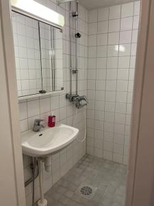een witte badkamer met een wastafel en een spiegel bij Apartment Kustaa in Kokkola