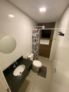 uma casa de banho com um lavatório e um WC em Residencial Brisa do Mar em Bombinhas