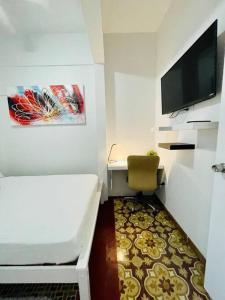 a room with a bed and a desk and a tv at Jireh 1 ¤ Near to Airport¤ in San Juan