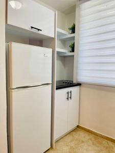 a kitchen with a white refrigerator and a window at Jireh 1 ¤ Near to Airport¤ in San Juan