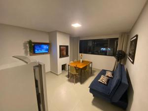 uma sala de estar com um sofá azul e uma mesa em Residencial Brisa do Mar em Bombinhas