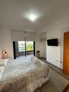 ラプラタにあるSemipiso premium con piscina y cochera opcionalのベッドと薄型テレビのある寝室