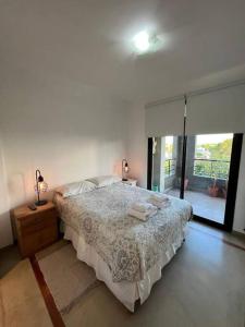 um quarto branco com uma cama e uma janela em Semipiso premium con piscina y cochera opcional em La Plata