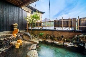 a hot spring with a bench and some birds in the water at Yawaragi-no-Sato Yadoya in Yufu