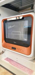 an orange microwave sitting on top of a shelf at Charmantes Häuschen mit Garten und Parkplatz in Boltenhagen